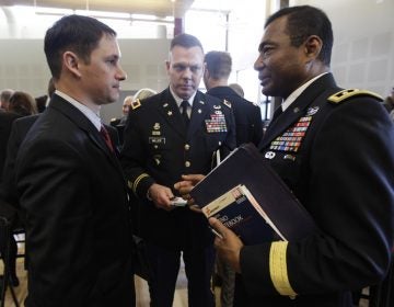 John Millan, (left), a 17-year member of the Washington Army National Guard who was diagnosed with PTSD in 2005 after serving in Iraq, talks with U.S. Army Lt. Gen. Thomas Bostick, (right), deputy chief of staff, G-1, as Col. Mike Miller, (center), looks on, following a field hearing of the U.S. Senate Veterans' Affairs Committee, Wednesday, April 4, 2012, in Tacoma, Wash. (Ted S. Warren/AP Photo)