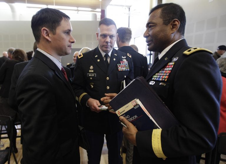 John Millan, (left), a 17-year member of the Washington Army National Guard who was diagnosed with PTSD in 2005 after serving in Iraq, talks with U.S. Army Lt. Gen. Thomas Bostick, (right), deputy chief of staff, G-1, as Col. Mike Miller, (center), looks on, following a field hearing of the U.S. Senate Veterans' Affairs Committee, Wednesday, April 4, 2012, in Tacoma, Wash. (Ted S. Warren/AP Photo)