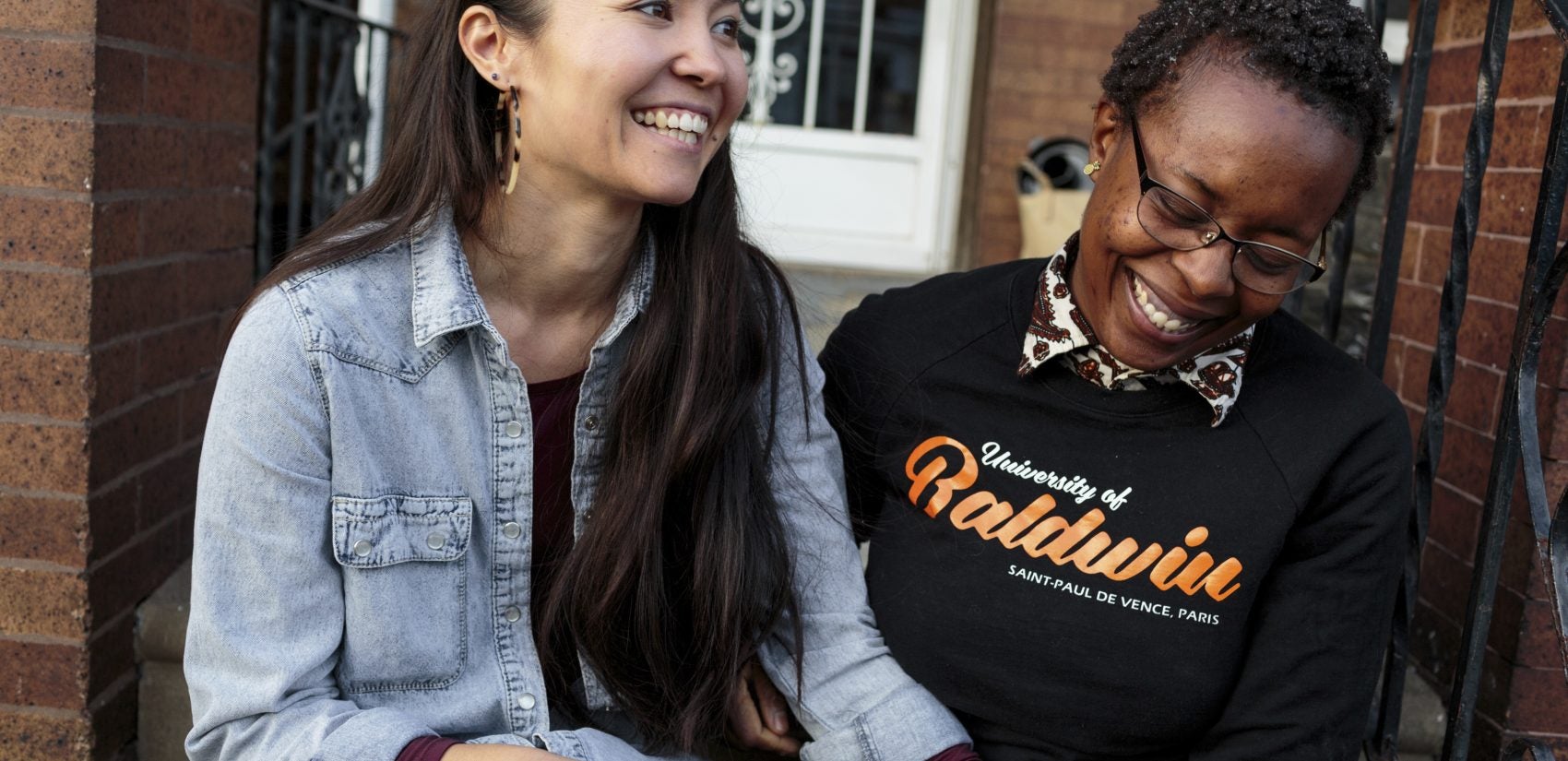 Rachelle Faroul, right, and her partner, Hanako Franz, sit outside their new home in Philadelphia