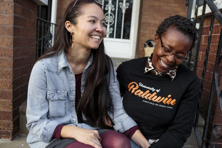 Rachelle Faroul, right, and her partner, Hanako Franz, sit outside their new home in Philadelphia