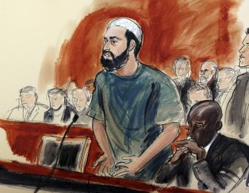 In this courtroom drawing, defendant Ahmad Khan Rahimi reads a statement to the judge during his sentencing hearing in New York, Tuesday, Feb. 13, 2018. Rahimi was sentenced to multiple terms of life in prison for setting off small bombs in two states, including a pressure cooker device that blasted shrapnel across a New York City block. At right is attorney Xavier Donaldson, Rahmin's attorney. (Elizabeth Williams via AP)