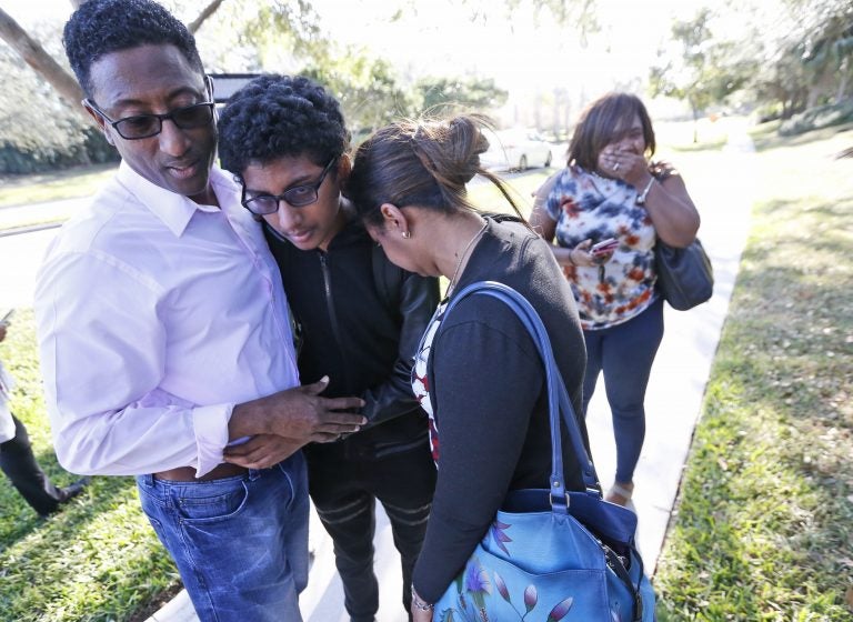 Family members embrace after a student walked out from Marjory Stoneman Douglas High School, Wednesday, Feb. 14, 2018, in Parkland, Fla. The shooting at the South Florida high school sent students rushing into the streets as SWAT team members swarmed in and locked down the building. Police were warning that the shooter was still at large even as ambulances converged on the scene and emergency workers appeared to be treating those possibly wounded.