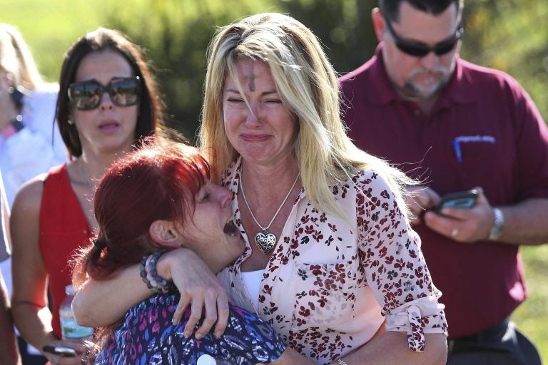 Parents wait for news after a reports of a shooting at Marjory Stoneman Douglas High School in Parkland, Fla., on Wednesday, Feb. 14, 2018. (