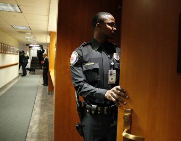 A security guard checks inside of a meeting room after it was evacuated by police with the Department of Homeland Security, where the Federal Communications Commission (FCC) was about to vote on net neutrality, Thursday, Dec. 14, 2017, in Washington. The room was shortly declared to be safe and the meeting continued where the FCC voted along party lines to repeal net neutrality. (Jacquelyn Martin/AP Photo)