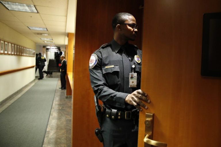 A security guard checks inside of a meeting room after it was evacuated by police with the Department of Homeland Security, where the Federal Communications Commission (FCC) was about to vote on net neutrality, Thursday, Dec. 14, 2017, in Washington. The room was shortly declared to be safe and the meeting continued where the FCC voted along party lines to repeal net neutrality. (Jacquelyn Martin/AP Photo)