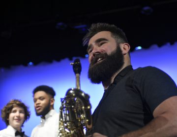Super Bowl Champion and Philadelphia Eagles center Jason Kelce joins the jazz band of his alma mater, Cleveland Heights High School, on stage during a music exchange program visit at Central High School in Philadelphia, Pa. on Feb. 22, 2018. (Bastiaan Slabbers/for WHYY)