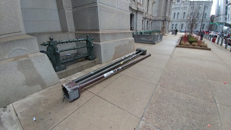 Lights ripped from their bases at City Hall lie on the sidewalk the morning after the Eagles' Super Bowl win