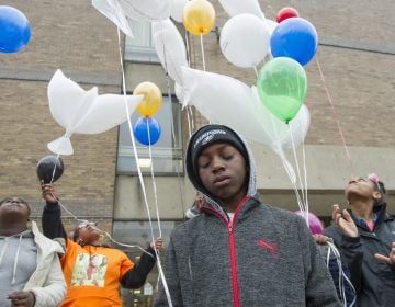 Alan Williams, whose aunt was murdered, cries as balloons honoring murder victims are released. (Jonathan Wilson for WHYY)
