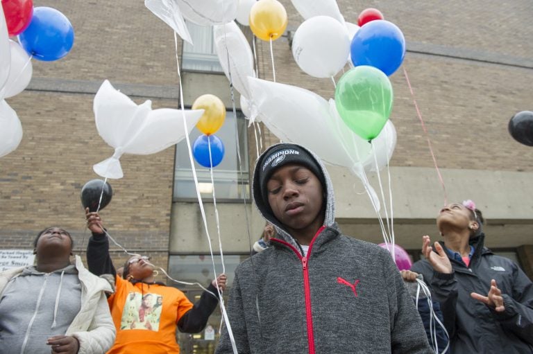 Alan Williams, whose aunt was murdered, cries as balloons honoring murder victims are released. (Jonathan Wilson for WHYY)