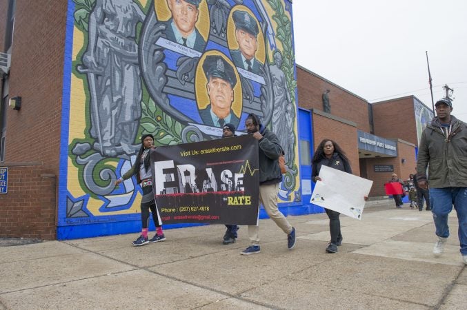 Marchers pass the 35th Police District in the Olney section of the city. (Jonathan Wilson for WHYY)