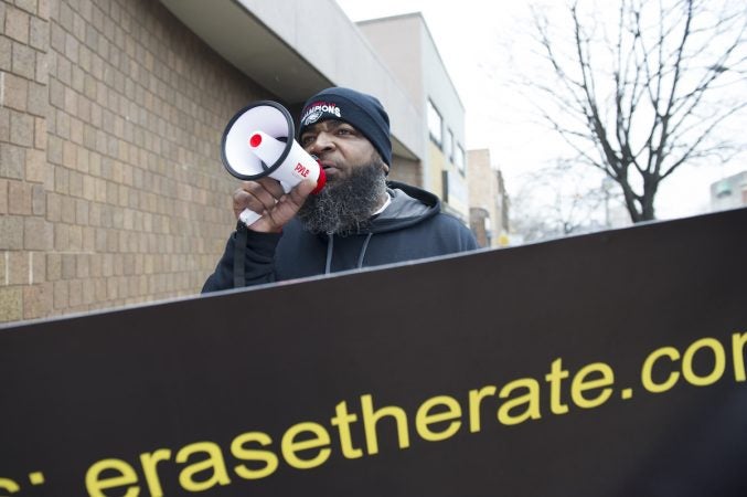 Radio personality Ikey Raw encourage passers by to join the march. Jonathan Wilson for WHYY)