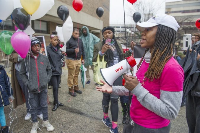 Erase the Rate founder Davida Garner, addresses marchers assembled in the parking lot of the Philadelphia Medical Examiner's office. (Jonathan Wilson for WHYY)