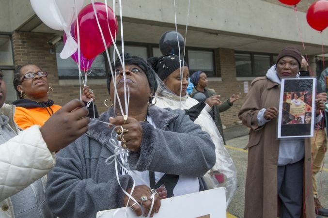 Diane Williams, whose 22 year old son Howard Williams was murdered prepares to release balloons in his honor. (Jonathan Wilson for WHYY)