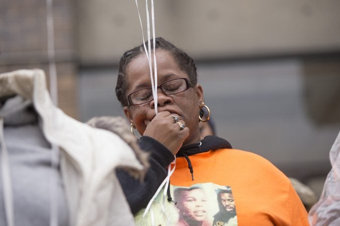 Moms Bonded by Grief member Johndell Gredic observes a moment of silence. (Jonathan Wilson for WHYY)