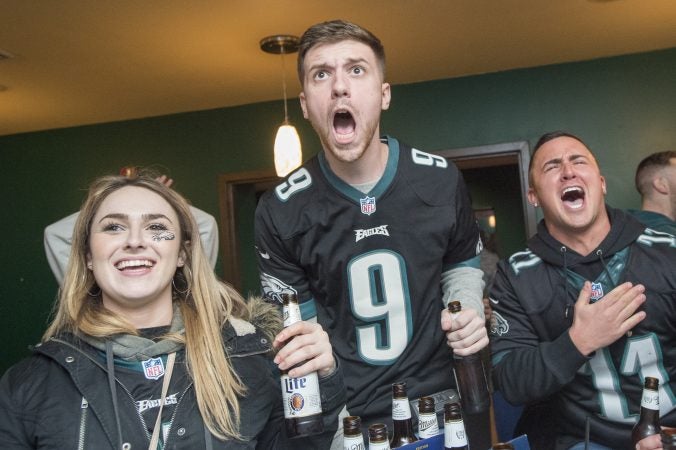 At Jon's Bar & Grille, patrons cheer as the Eagles score early in the game.