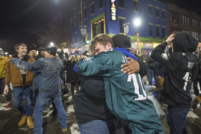 Eagles fans embrace at Fourth and South Streets.
