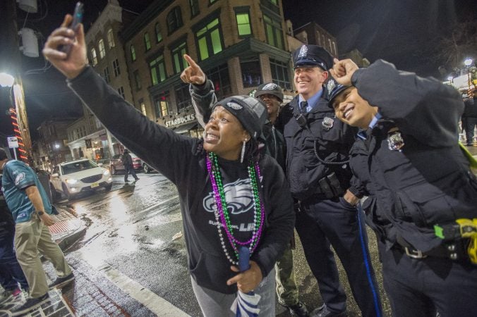 A woman takes a selfie with Philadelphia Police officers.