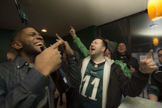 Eagles fans at Jon's at 3rd and South Streets cheer the team hours before the Super Bowl begins.