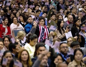 People wave U.S. flags during a 2017 naturalization ceremony at the Los Angeles Convention Center. (Jae C. Hong/AP)