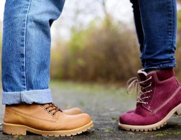 Closeup photo of male and female legs during a date in autumn park. Love couple romantic concept