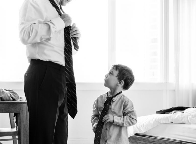 Father teaching the son how to tie a necktie