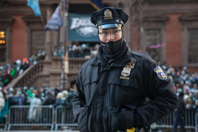 Officer Seymour keeps watch as he tries to stay warm, just like the over a million fans who flocked to Center City and stood in the freezing temperatures to cheer on their winning Eagles for the Super Bowl Champions parade in Philadelphia February 8th 2018. (Emily Cohen for WHYY)