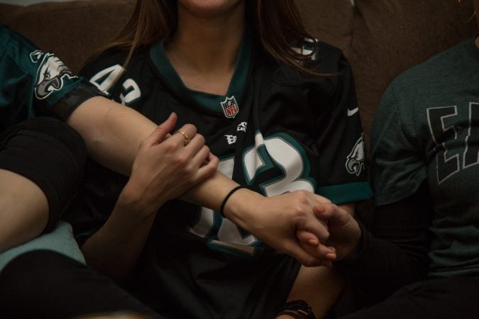 Friends grasp for each other while watching the Super Bowl in Philadelphia February 4th 2018.