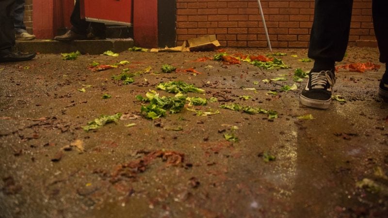 Wrapers from firecrackers and lettuce, which represents money and prosperity, litters the ground after a lion dance in celebration of the Chinese New Year in Phildelphia's Chinatown on February 15, 2018. (Emily Cohen for WHYY)