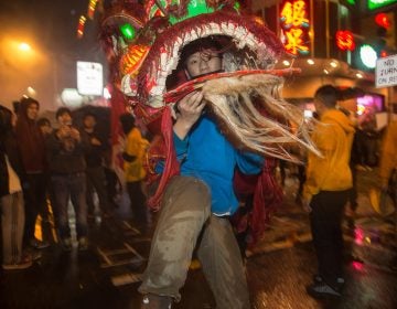 A member of the Philly Suns does a lion dance through the streets of Chinatown in celebration of the Chinese New Year on February 15th 2018. (Emily Cohen for WHYY)
