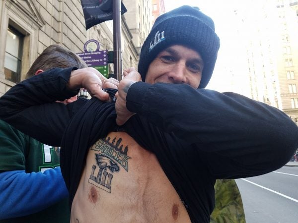 Jason Yurchak lifts up 13 layers of clothing to show his new Eagles Super Bowl Championship tattoo.
