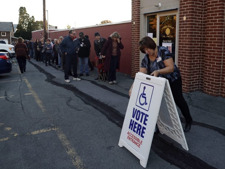 An election official places a sign as voters line up outside a polling place November 2016 in Fogelsville, Pa. (AP Photo/Matt Slocum)