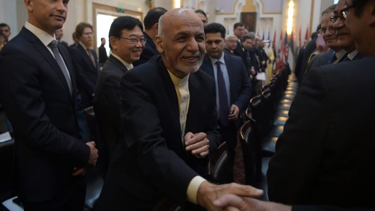 Afghan President Ashraf Ghani shakes hands with a foreign delegate at the Kabul Process conference in the country's capital Wednesday. During the conference, Ghani called on the Taliban to participate in peace talks with the Afghan government. (Shah Marai/AFP/Getty Images)