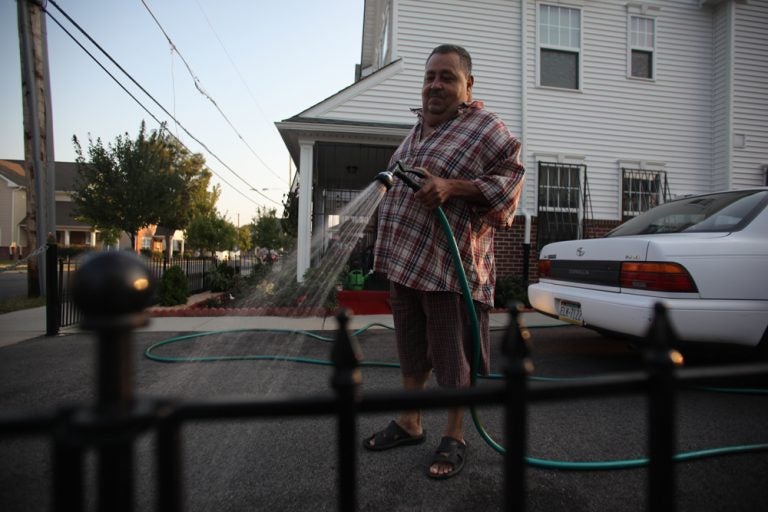 Manuel Pomeles waters his garden in the North Central neighborhood revitalized with support from HUD's axed Choice Neighborhoods program. (Jake Blumgart/PlanPhilly)