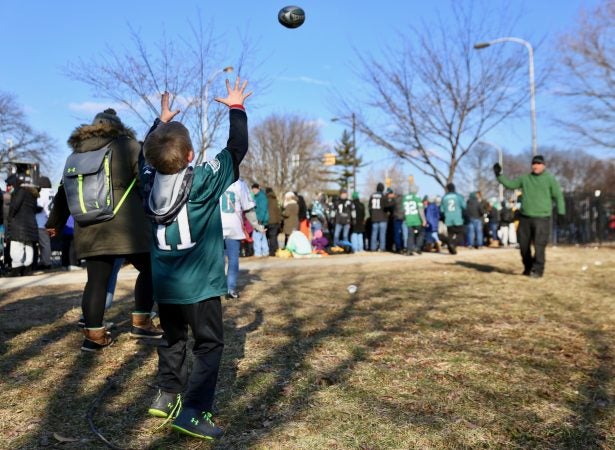 Grant DeCosta throws a spiral to his son, Luke, 8, as they wait to greet Super Bowl Champions: the Philadelphia Eagles.