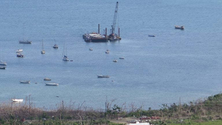 Coral Bay, on the eastern end of St. John, is home to an active sailing community. For months, the Coast Guard has been using a crane boat and barge to retrieve sunken vessels. (Greg Allen/NPR)