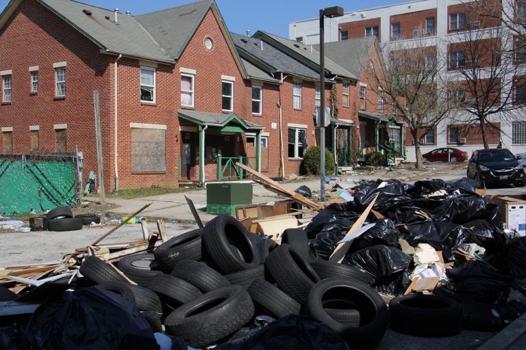 Garbage is piled in front of an apartment complex in Lower Germantown. (Emma Lee/WHYY)