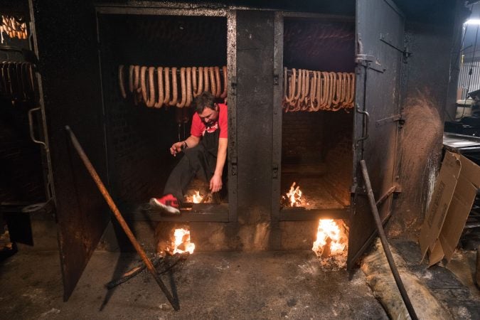 John Czerw steps out of the smokehouse at Czerw's Polish Kielbasa in Port Richmond. (Branden Eastwood for WHYY)