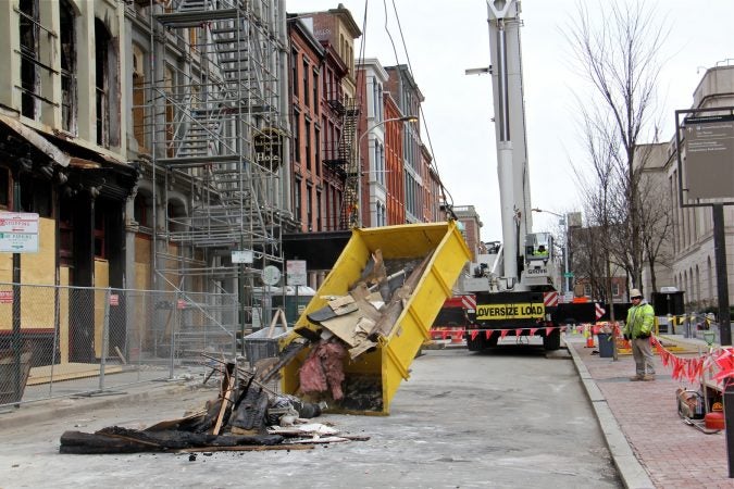 A load of debris is dumped onto Chestnut Street. (Emma Lee/WHYY)