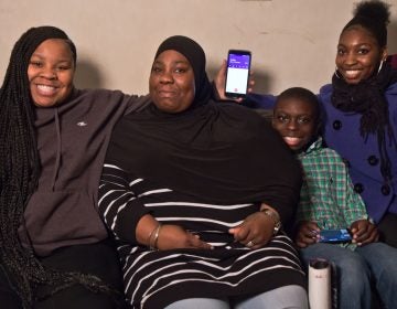 Nekia Pressley and three of her children take a break while on the phone with her husband, Demetris McDuffy, who is serving a life sentence he received as a juvenile. Pressley's daughter Yani (left) sits beside her mother, along with son Darwish and daughter Yasmeen (right).