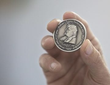 Head of the Mikdash Educational Center, Rabbi Mordecahi Persoss, holds a coin they minted bearing President Donald Trump's image to honor his recognition of Jerusalem as Israel's capital, in Tel Aviv, Israel, Wednesday, Feb. 28, 2018. The center said Wednesday that the 