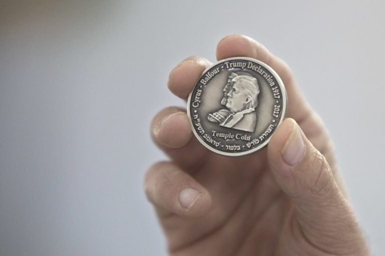 Head of the Mikdash Educational Center, Rabbi Mordecahi Persoss, holds a coin they minted bearing President Donald Trump's image to honor his recognition of Jerusalem as Israel's capital, in Tel Aviv, Israel, Wednesday, Feb. 28, 2018. The center said Wednesday that the 