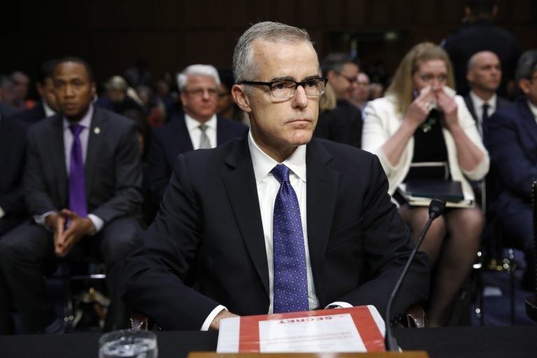 Acting FBI Director Andrew McCabe sits with a folder marked 