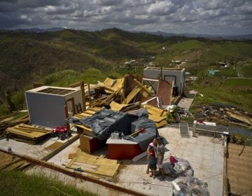 A family stand next to their belongings, in front of the remains of their home destroyed by Hurricane Maria, in the San Lorenzo neighborhood of Morovis, Puerto Rico, Saturday, Oct. 7, 2017. (Ramon Espinosa/AP Photo)