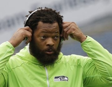 Seattle Seahawks defensive end Michael Bennett wears headphones as he stands on the field during warmups before an NFL football game against the Houston Texans, Sunday, Oct. 29, 2017, in Seattle. (Elaine Thompson/AP Photo)