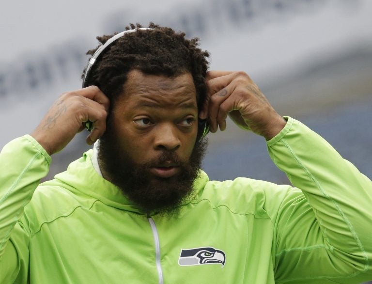 Seattle Seahawks defensive end Michael Bennett wears headphones as he stands on the field during warmups before an NFL football game against the Houston Texans, Sunday, Oct. 29, 2017, in Seattle. (Elaine Thompson/AP Photo)