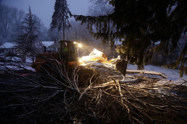 Streets department worker James Ockimey clears a downed tree during the storm Friday in Marple Township, Delaware County.  The nor'easter pounded the Atlantic coast with hurricane-force winds and sideways rain and snow, flooding streets, grounding flights, stopping trains and leaving 1.6 million customers without power from North Carolina to Maine. Tens of thousands of homes in the Philadelphia region were still without power Sunday. (AP Photo/Matt Slocum)