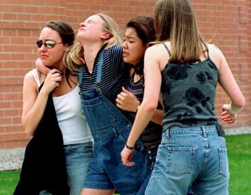 On April 20, 1999, unidentified young women head to a library near Columbine High School where students and faculty members were evacuated after two gunmen went on a shooting rampage in the school in the southwest Denver suburb of Littleton, Colorado.. Fifteen people, including the two shooters, died. (Kevin Higley/AP Photo)