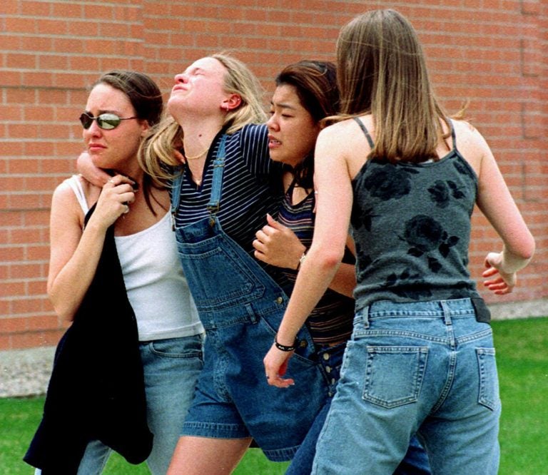 On April 20, 1999, unidentified young women head to a library near Columbine High School where students and faculty members were evacuated after two gunmen went on a shooting rampage in the school in the southwest Denver suburb of Littleton, Colorado.. Fifteen people, including the two shooters, died. (Kevin Higley/AP Photo)