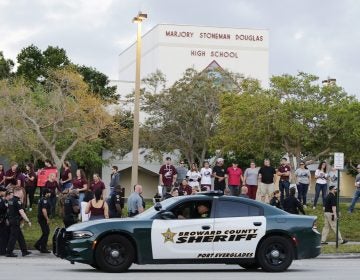In this Feb. 28, 2018 photo, a police car drives by Marjory Stoneman Douglas High School in Parkland, Fla., as students returned to class for the first time since a former student opened fire there with an assault weapon.  (Terry Renna/AP Photo)