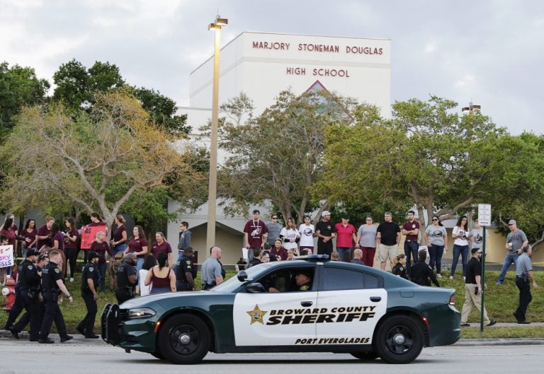 In this Feb. 28, 2018 photo, a police car drives by Marjory Stoneman Douglas High School in Parkland, Fla., as students returned to class for the first time since a former student opened fire there with an assault weapon.  (Terry Renna/AP Photo)